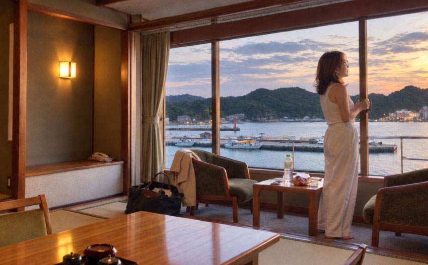 ホテル浦島_なぎさ館の部屋から外を見る女性