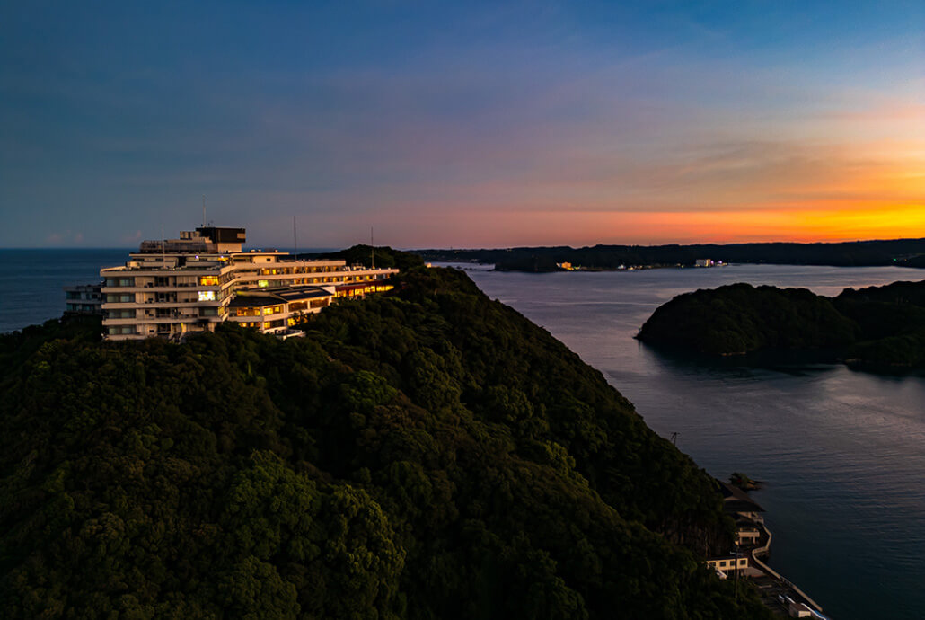 夕焼け空と海に囲まれた高台の山上館